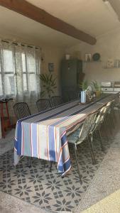 a table with chairs and a striped table cloth on it at Mas de la Bimarde in Monteux