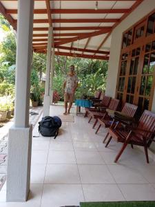 a man standing under a pavilion with chairs and a table at Green Gardens in Weligama +3 photos