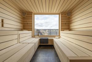a sauna with a window and a chair in it at Arthotel Bakker in Borkum