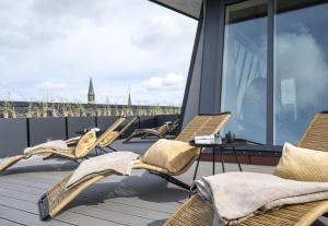 a balcony with chairs and a table on a roof at Arthotel Bakker in Borkum