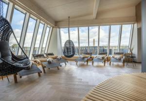 a living room with a lot of chairs and windows at Arthotel Bakker in Borkum