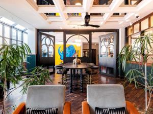 a room with a table and chairs and plants at Mercure Hotel Frankfurt Airport Langen in Langen
