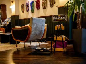 a living room with chairs and a sign on the wall at Mercure Hotel Frankfurt Airport Langen in Langen
