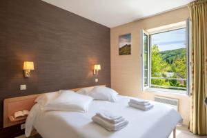 a bedroom with a large white bed with a window at Village Vacances L'Oustal in Salles-la-Source