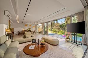 a living room with a large tv and a table at Dreamy Beach Villas Danang in Danang