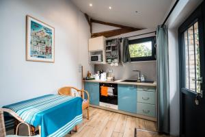 a small kitchen with blue cabinets and a sink at P'tite Maizoun - Gîte in Hermanville-sur-Mer