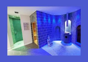 a blue tiled bathroom with a toilet and a shower at The Chase Golf & Country Club in Penkridge +52 photos