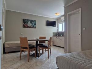 a room with a table and chairs and a bedroom at Sigma Hotel in Paralia Vrachou