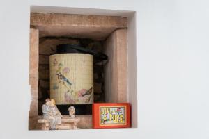 a shelf with a barrel and a book and a picture at P'tite Maizoun - Gîte in Hermanville-sur-Mer