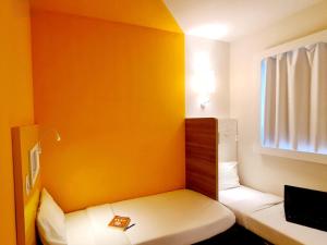 a small room with a bed and a yellow wall at ibis budget Petropolis in Petrópolis +91 photos