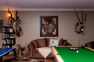 a living room with a couch and a pool table at Big 5 Guest House Witbank in eMalahleni