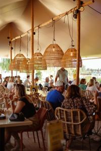 a group of people sitting at tables in a restaurant at Luxury Lake Cabin in Alphen