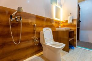 a bathroom with a toilet and a shower and a sink at Falcon'S Cottages in Meruk