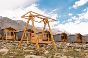 a group of lodges in a field with mountains at Falcon'S Cottages in Meruk