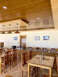 a dining room with wooden tables and chairs at Falcon'S Cottages in Meruk +16 photos