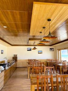 a restaurant with wooden ceilings and wooden tables and chairs at Falcon'S Cottages in Meruk
