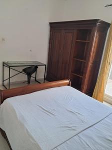 a bedroom with a bed and a dresser and a table at Rdc in Ouakam