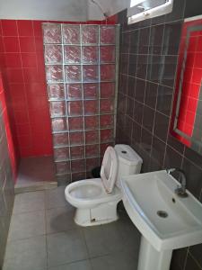a bathroom with a white toilet and a sink at Rdc in Ouakam