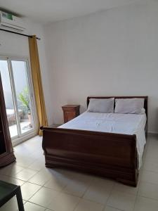 a bedroom with a bed and a large window at Rdc in Ouakam