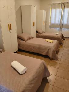 a room with three beds with towels on them at Flats Rio Branco in Uberaba