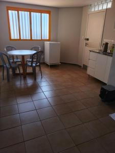 a room with a table and chairs and a kitchen at Flats Rio Branco in Uberaba +17 photos