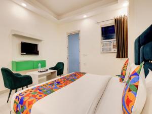 a bedroom with a bed and a desk and a chair at Hotel Paradise Palace in Ghaziabad