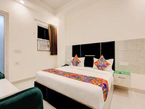 a bedroom with a large white bed with colorful pillows at Hotel Paradise Palace in Ghaziabad +15 photos