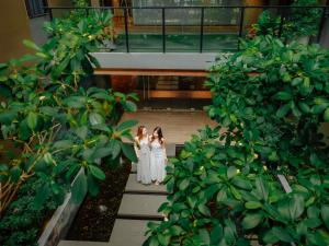 two girls in white dresses walking down the stairs at ibis Styles Bangkok Ratchada in Bangkok