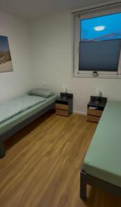 a room with two beds and a large window at Haus Bahnhofsblick in Ottersberg
