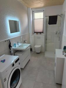 a bathroom with a washing machine and a sink at Haus Bahnhofsblick in Ottersberg