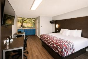a hotel room with a bed and a desk at Envi Boutique Hotel Henderson-Evansville South in Henderson
