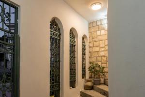a hallway with four stained glass windows and stairs at Apartments Nuhi in Ulcinj