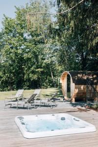 a jacuzzi tub sitting on a deck with chairs at Villa de Luxe à Malmedy pour 14 personnes en Ardenne in Malmedy