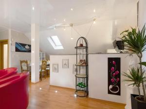 a living room with a red chair and a shelf with plants at Urlaubsoase am Nahesteig in Nohen