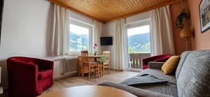 a living room with a couch and a table and two windows at Boutique73 Sunset in Altossiach