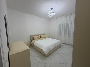 a bedroom with a bed in a white room at Alison Guest House in Durrës