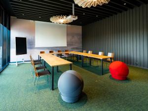 a conference room with a table and chairs and a screen at ibis Tallinn Center in Tallinn