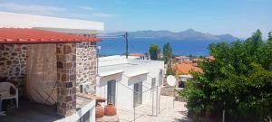 a house with a view of the water at Volcanic Stone Cottage Sea View & Yard in Kipséli