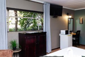 a room with a kitchen and a window with a microwave at Big 5 Guest House Witbank in eMalahleni