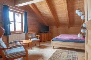 a bedroom with a bed and a tv in a room at Allgäu Holzhaus I Bergpanorama & Natur pur im Herzen des Allgäus! in Weitnau