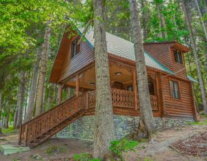 a log cabin in the woods with a large deck at Rest House in Oni