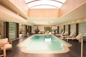 a swimming pool in a lobby with a skylight at Le Relais de La Malmaison, a member of Radisson Individuals in Rueil-Malmaison