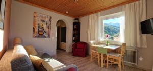 a living room with a couch and a table and a window at Boutique73 Sunset in Altossiach