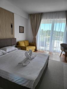 a hotel room with a bed with a towel on it at Sunset Beach Studio by Blaxy Resort Olimp in Olimp