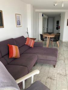 a living room with a purple couch and a table at Beachfront Apartment with Sea Views & Private Parking in San Pol de Mar