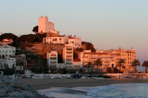 a group of buildings on a hill next to a beach at Beachfront Apartment with Sea Views & Private Parking in San Pol de Mar