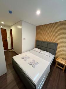 a bedroom with a large white bed with flowers on it at LUNA by LCB Apartelle and Resort Tagaytay in Tagaytay +23 photos