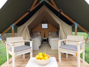 two chairs and a bowl of fruit in a tent at casa la luna glamping in Alhaurín el Grande