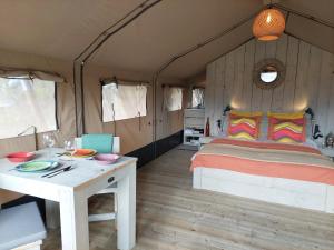 a bedroom with a bed and a table with plates on it at casa la luna glamping in Alhaurín el Grande