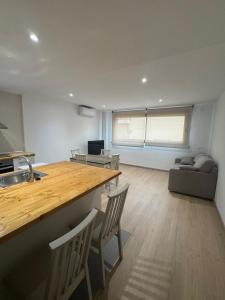 a kitchen and living room with a table and chairs at Set Blau Apartamentos in El Prat de Llobregat